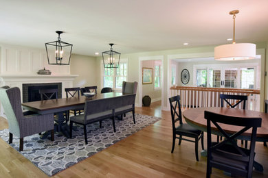 Mid-sized transitional light wood floor and beige floor kitchen/dining room combo photo in Columbus with beige walls, a standard fireplace and a wood fireplace surround