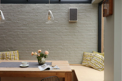 Ejemplo de comedor de cocina nórdico de tamaño medio con paredes grises y suelo de madera clara