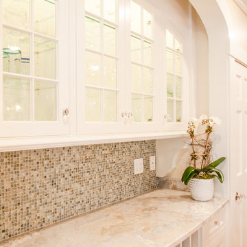 Recessed serving area with glass, mosaic tile backsplash.