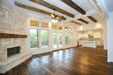 ダラスにある広いトランジショナルスタイルのおしゃれなLDK (白い壁、無垢フローリング、標準型暖炉、石材の暖炉まわり、茶色い床) の写真