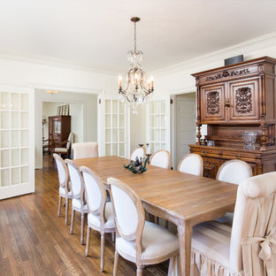 Idee per una grande sala da pranzo chiusa con pareti bianche, pavimento in legno massello medio, nessun camino e pavimento marrone