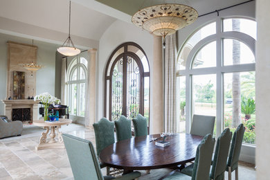 Example of a large classic travertine floor dining room design in Houston with gray walls and no fireplace
