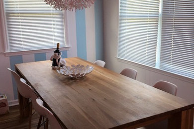 Immagine di una sala da pranzo aperta verso la cucina costiera con pavimento in vinile e pavimento marrone