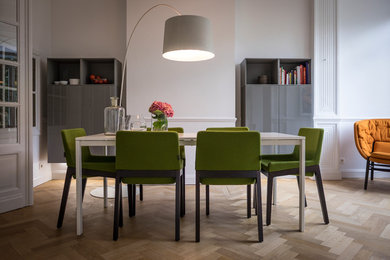 This is an example of a contemporary dining room in Brussels with white walls and feature lighting.
