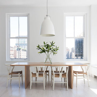 Example of a danish light wood floor and white floor dining room design in New York with white walls