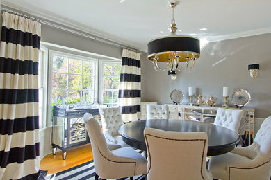Example of a large trendy light wood floor enclosed dining room design in Los Angeles with gray walls