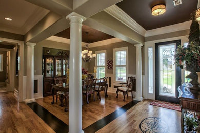 Foto de comedor clásico de tamaño medio abierto con paredes grises, suelo de madera en tonos medios y suelo marrón