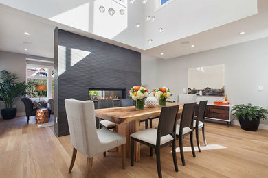 Example of a large trendy light wood floor great room design in San Francisco with white walls, a two-sided fireplace and a concrete fireplace