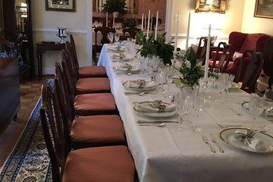 Medium sized traditional enclosed dining room in DC Metro with yellow walls, light hardwood flooring, a wooden fireplace surround and brown floors.