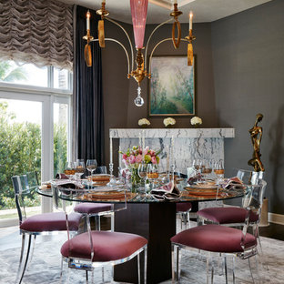 Ispirazione per una sala da pranzo design chiusa e di medie dimensioni con pareti grigie, moquette, camino ad angolo, pavimento grigio e cornice del camino in pietra