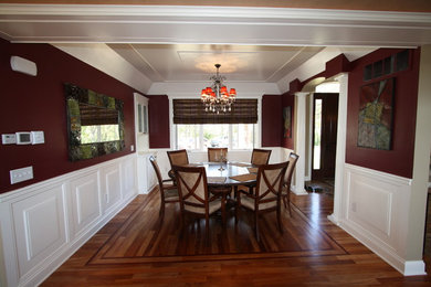 Ispirazione per una sala da pranzo aperta verso il soggiorno tradizionale di medie dimensioni con pareti rosse e pavimento in legno massello medio