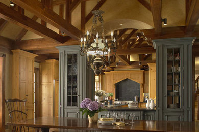 Example of a large classic dark wood floor kitchen/dining room combo design in Detroit with yellow walls, a two-sided fireplace and a stone fireplace