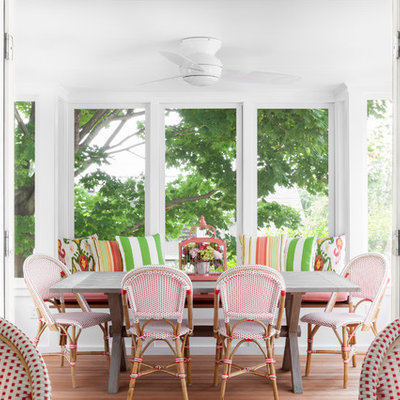 Enclosed dining room - coastal medium tone wood floor enclosed dining room idea in New York with white walls