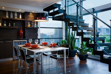 Cette image montre une salle à manger ouverte sur la cuisine design de taille moyenne avec un mur blanc et parquet foncé.