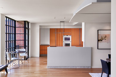 Immagine di una sala da pranzo aperta verso la cucina contemporanea di medie dimensioni con pareti bianche, parquet chiaro e pavimento marrone