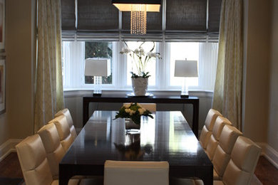 Large medium tone wood floor enclosed dining room photo in Toronto with beige walls
