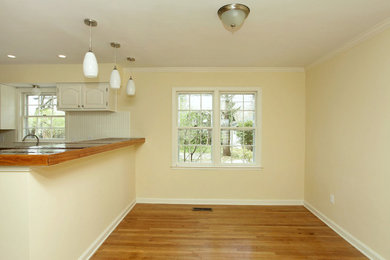 Example of a small trendy light wood floor kitchen/dining room combo design in Other with yellow walls