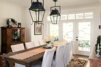 Example of a large cottage chic medium tone wood floor kitchen/dining room combo design in Vancouver with white walls
