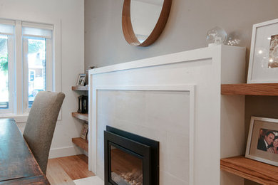 Example of a mid-sized transitional light wood floor and beige floor kitchen/dining room combo design in Toronto with gray walls, a standard fireplace and a tile fireplace