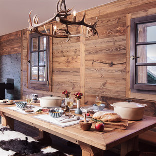 Idées déco pour une salle à manger ouverte sur le salon montagne de taille moyenne avec un mur marron et un sol en bois brun.