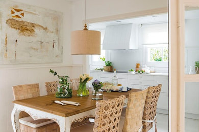 На фото: огромная кухня-столовая в средиземноморском стиле с белыми стенами и деревянным полом с