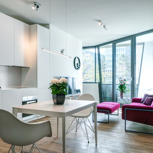 Mittelgroße Moderne Wohnküche ohne Kamin mit weißer Wandfarbe, braunem Holzboden und braunem Boden in Berlin