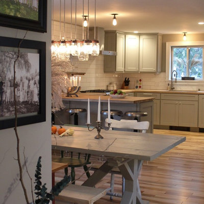 Inspiration for a small cottage medium tone wood floor and brown floor kitchen/dining room combo remodel in Boston with gray walls, a two-sided fireplace and a plaster fireplace
