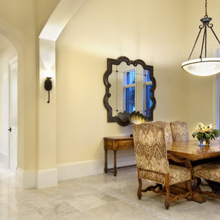 Immagine di una grande sala da pranzo mediterranea chiusa con pareti beige, pavimento in travertino e nessun camino