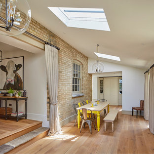 Photo of a farmhouse dining room in Wiltshire with white walls, medium hardwood flooring and brown floors.