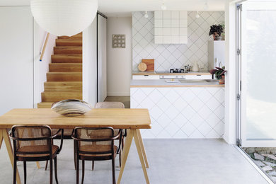 中くらいなコンテンポラリースタイルのおしゃれなダイニングキッチン (白い壁、コンクリートの床、グレーの床) の写真