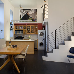 Idee per una piccola sala da pranzo aperta verso il soggiorno industriale con pareti bianche, pavimento nero, parquet scuro e nessun camino