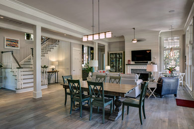 Immagine di una sala da pranzo aperta verso il soggiorno stile marinaro di medie dimensioni con pareti bianche, camino classico e cornice del camino in pietra