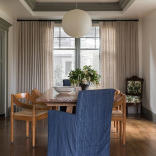 Example of a transitional medium tone wood floor and brown floor dining room design in Seattle with white walls