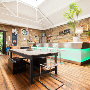 Bohemian dining room in London with medium hardwood flooring and brown floors.