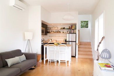 Ejemplo de comedor minimalista pequeño abierto con paredes blancas, suelo de madera clara y suelo marrón