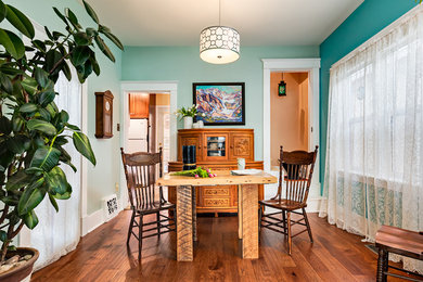 Immagine di una piccola sala da pranzo stile shabby chiusa con pareti blu, pavimento in legno massello medio e pavimento marrone