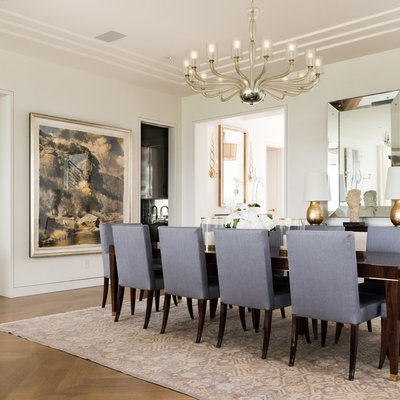 Example of a large transitional medium tone wood floor and brown floor enclosed dining room design in Dallas with white walls and no fireplace