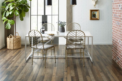 Cette image montre une salle à manger ouverte sur la cuisine design de taille moyenne avec un mur blanc, parquet foncé et un sol marron.