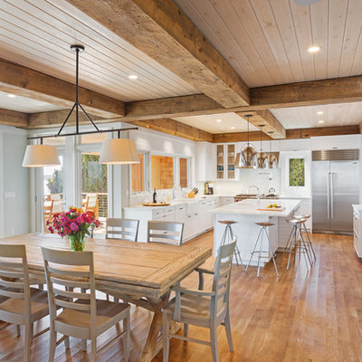 Example of a large beach style medium tone wood floor kitchen/dining room combo design in New York with gray walls and no fireplace