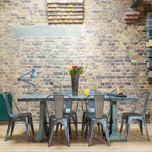 Idee per una grande sala da pranzo aperta verso il soggiorno industriale con pavimento in legno massello medio e pavimento marrone