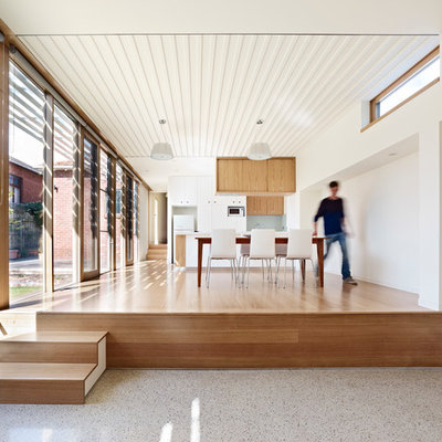 Mid-sized trendy medium tone wood floor kitchen/dining room combo photo in Melbourne with white walls and no fireplace
