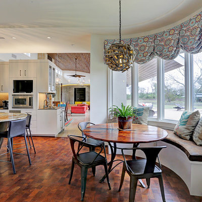 Large trendy medium tone wood floor and brown floor kitchen/dining room combo photo in Houston with white walls and no fireplace