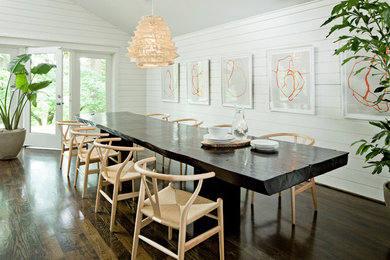 Exemple d'une salle à manger bord de mer avec un mur blanc et parquet foncé.