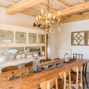 Réalisation d'une salle à manger méditerranéenne avec un mur blanc, aucune cheminée et un sol gris.