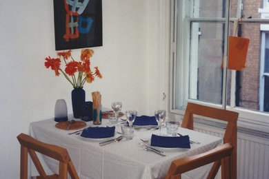 Aménagement d'une salle à manger ouverte sur la cuisine avec un mur blanc, parquet clair et aucune cheminée.