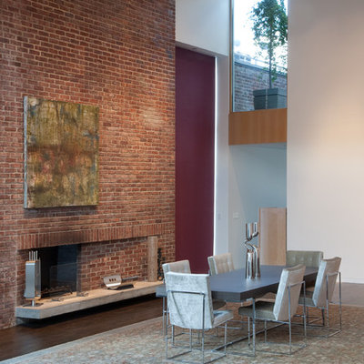 Huge trendy dark wood floor kitchen/dining room combo photo in New York with white walls, a standard fireplace and a brick fireplace