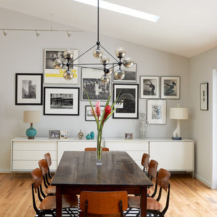 Imagen de comedor retro, grande, abierto, sin chimenea, con suelo de madera clara, paredes grises y suelo beige