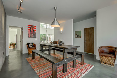Contemporary enclosed dining room in Austin with white walls, concrete flooring and no fireplace.