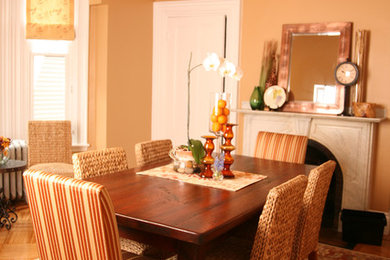 Dining room - traditional medium tone wood floor dining room idea in Boston with orange walls and a standard fireplace