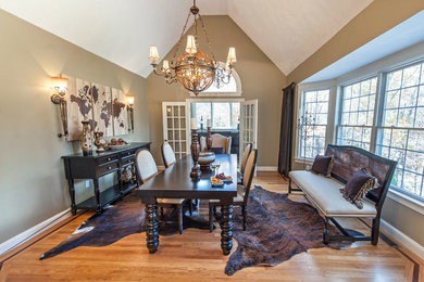 Example of a large classic medium tone wood floor enclosed dining room design in Boston with brown walls and no fireplace